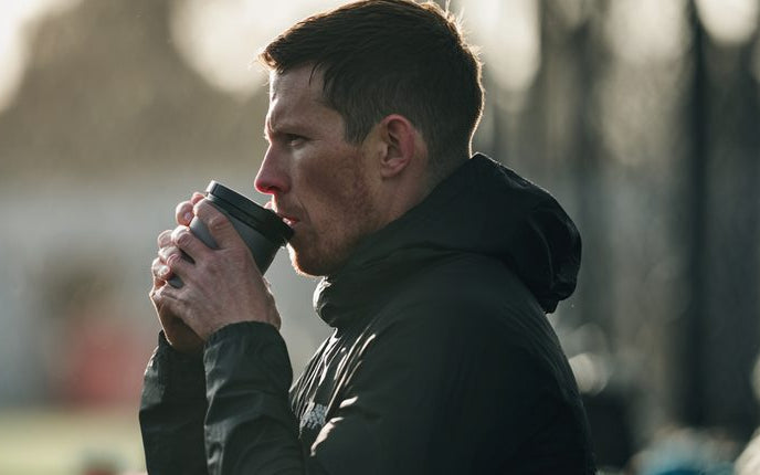 Athlete drinking coffee before training